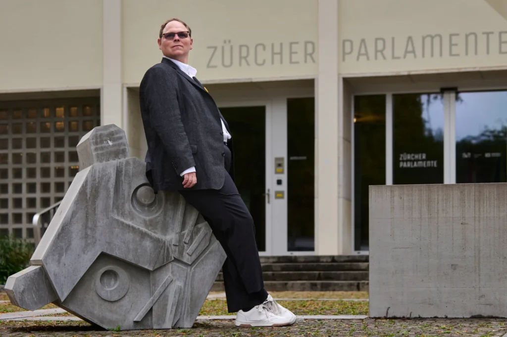 Ganzkörperfoto von Kevin Rauch, der vor dem Zürcher Parlament posiert.